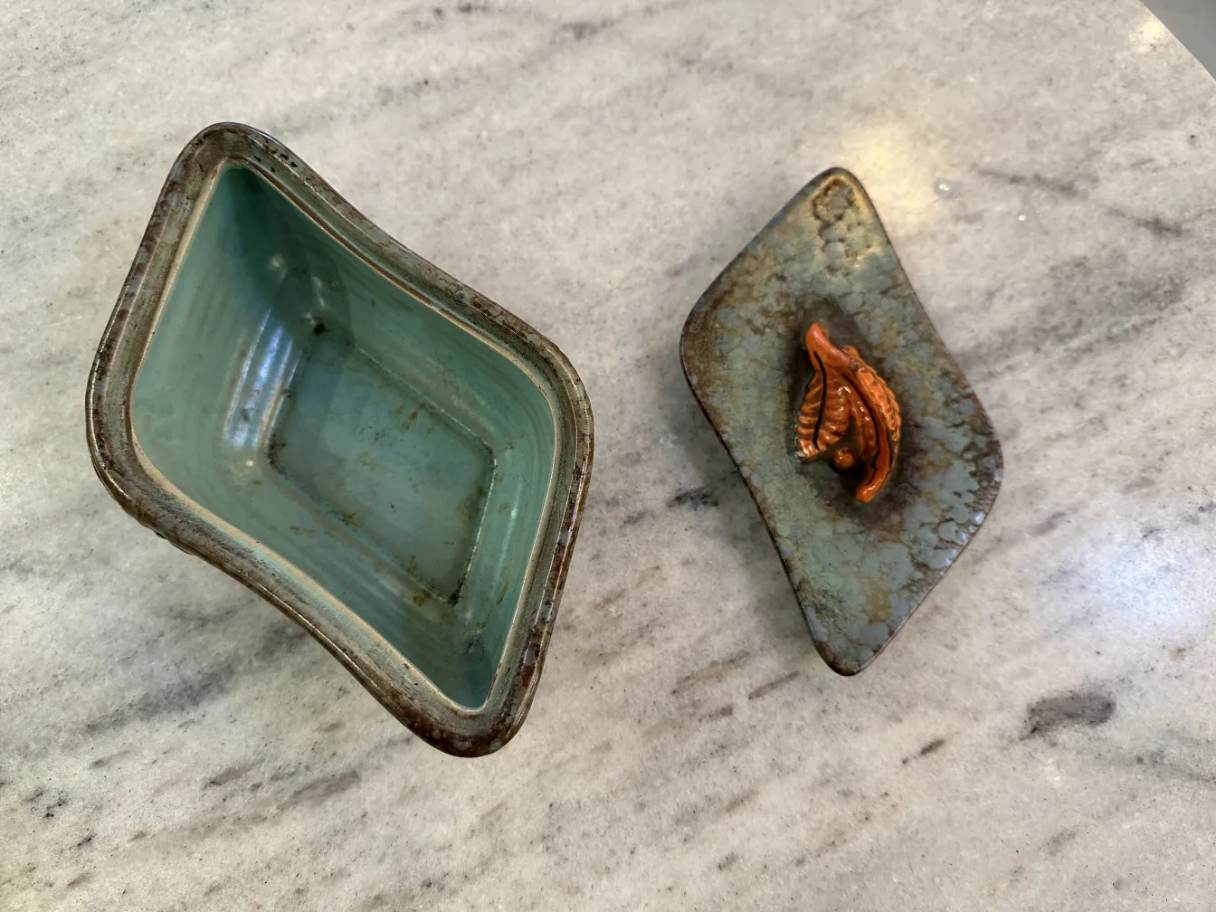 Antica ceramica decorata con foglie in tonalità di arancione e marrone