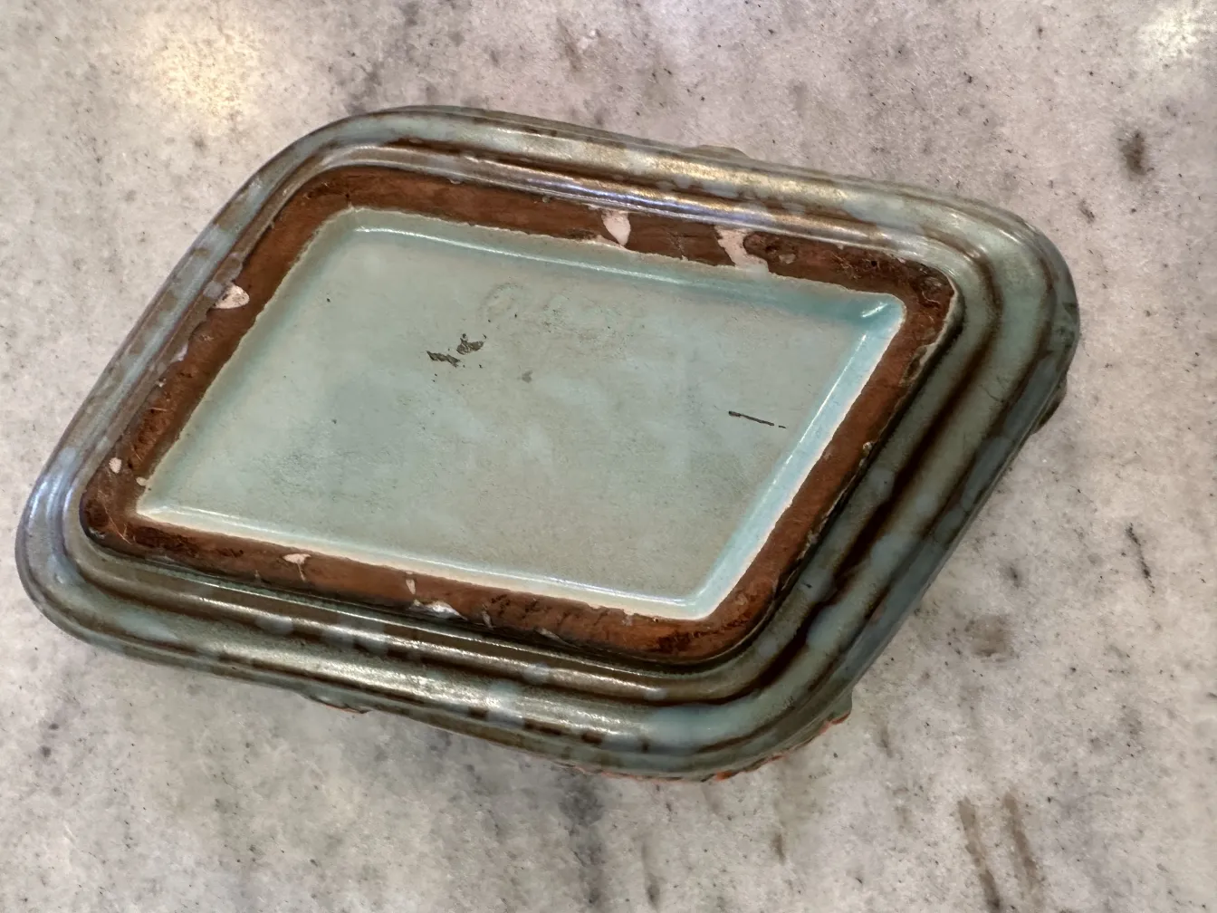 Antica ceramica decorata con foglie in tonalità di arancione e marrone