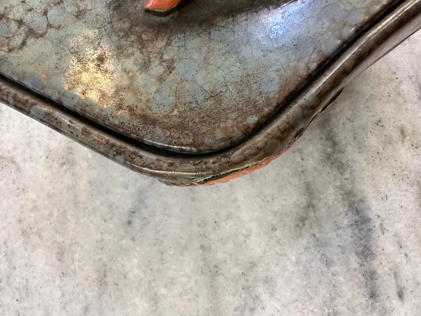 Ceramica antigua decorada con hojas en tonos naranja y marrón