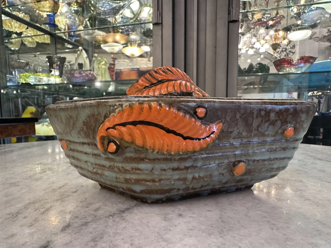Ceramica antigua decorada con hojas en tonos naranja y marrón