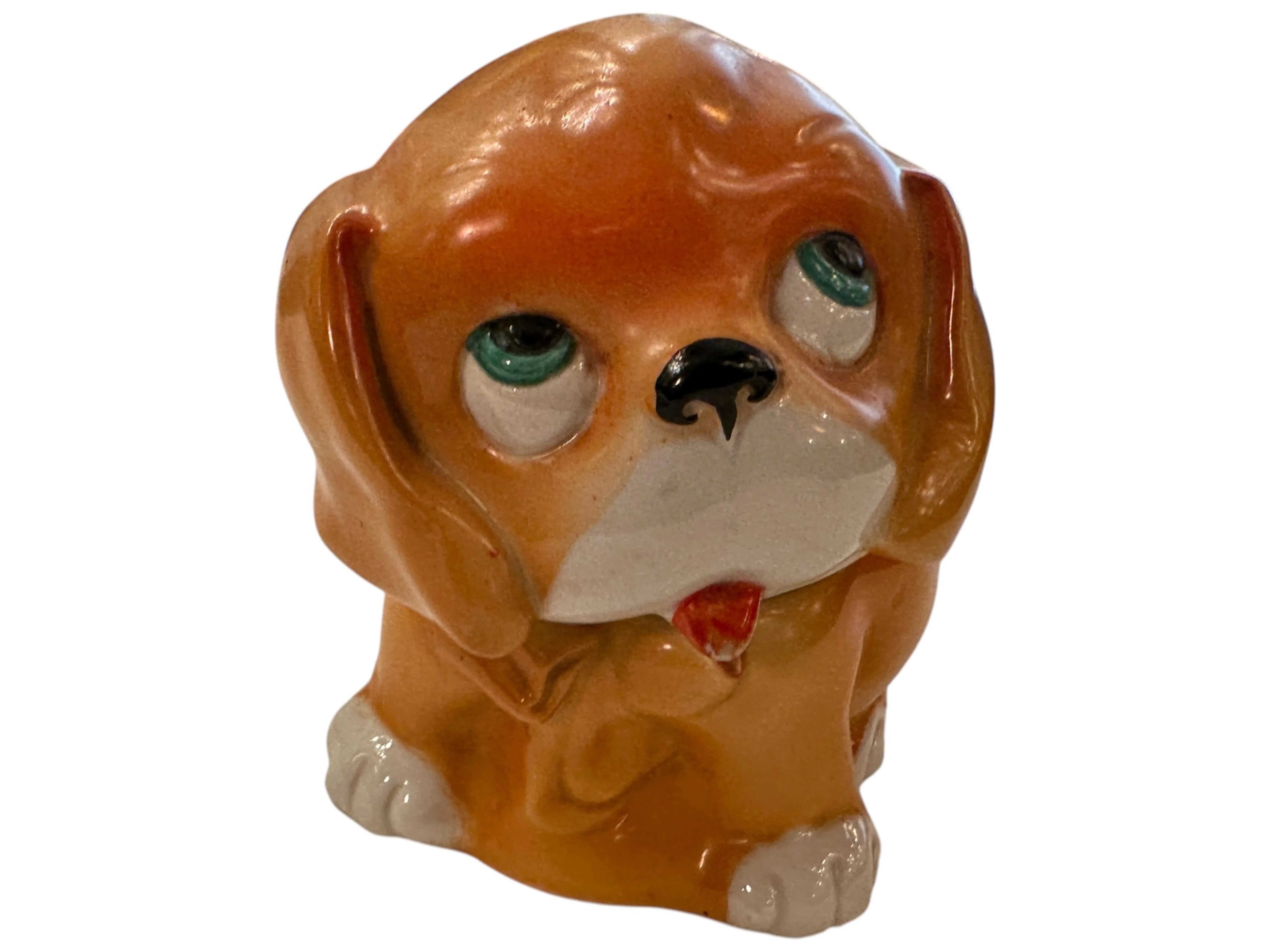 Figurina di cane in ceramica antica con occhi grandi ed espressione dolce.