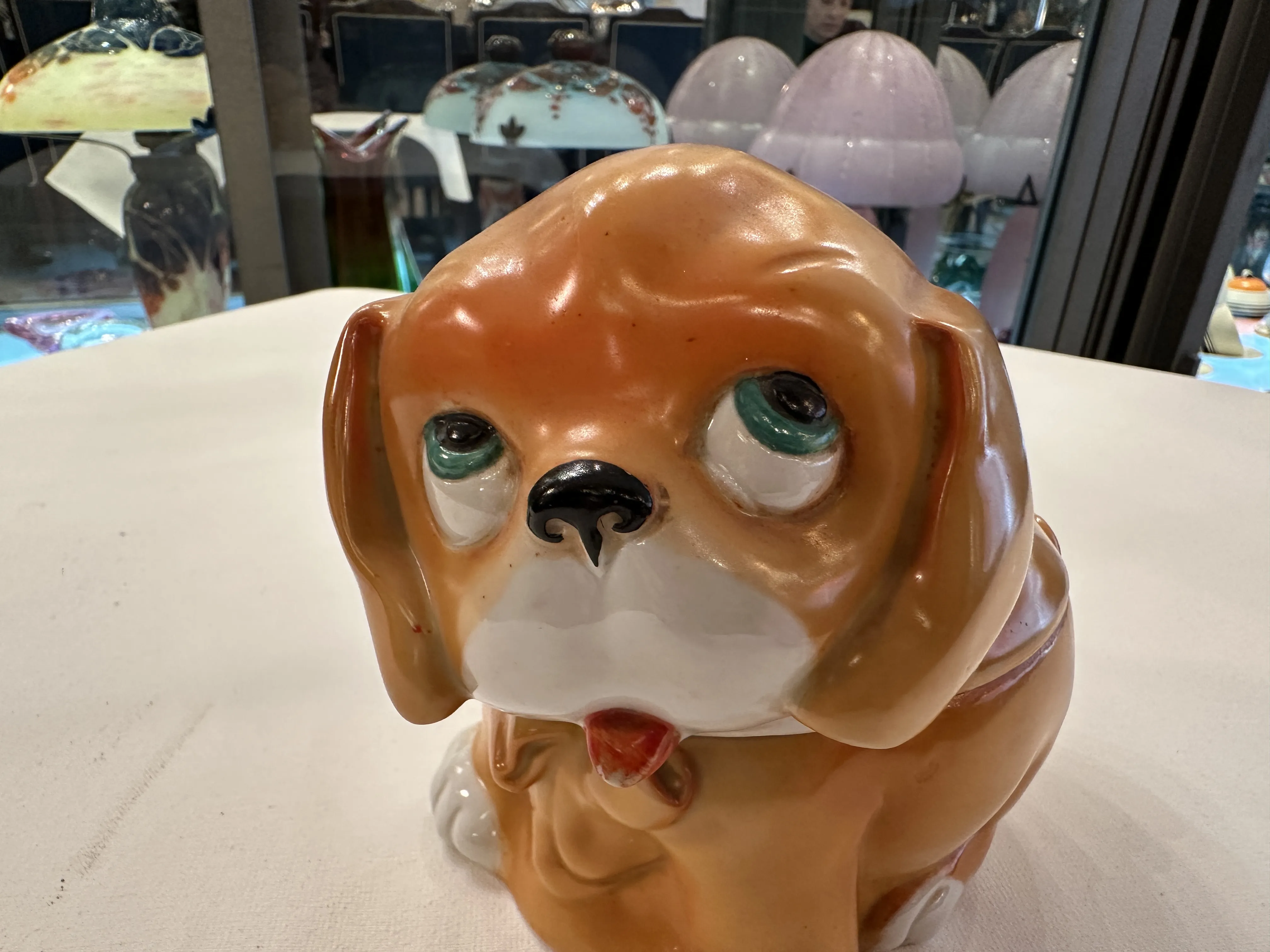 Figura de un perro de cerámica antiguo con ojos grandes y expresión fiel.