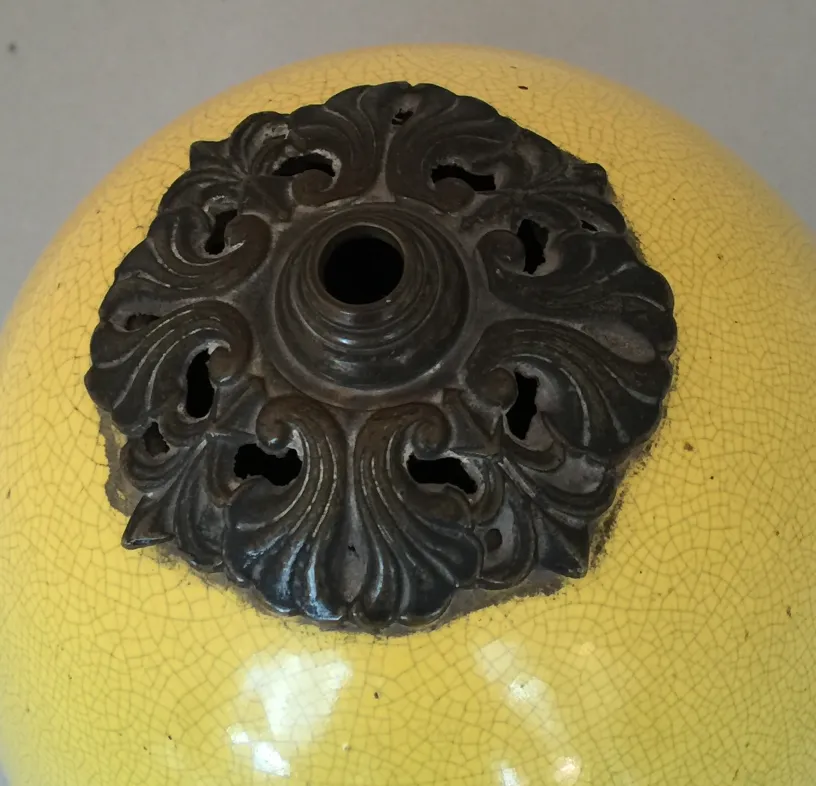 detail of an antique Art Deco table lamp in yellow with ornamental design