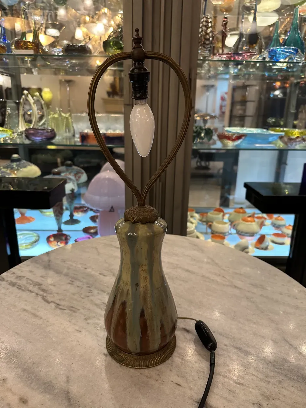 lampada da tavolo antica con forma distintiva e base decorativa su un tavolo