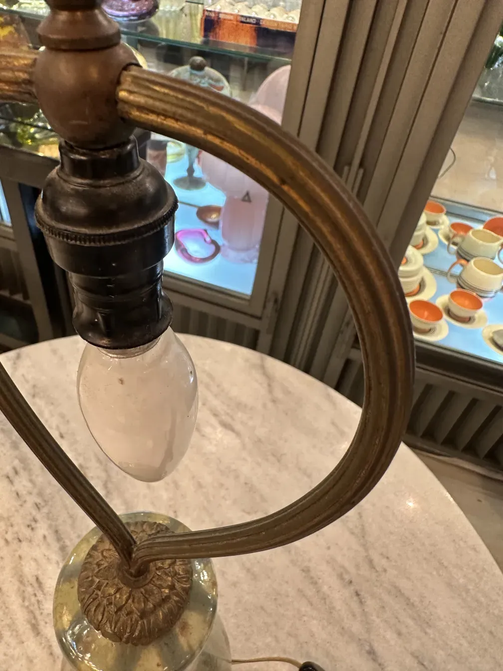古老的檯燈，具有独特的设计和装饰性底座，背景有复古物品。
