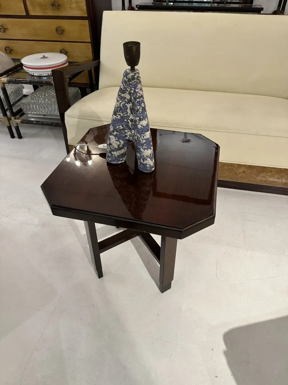 lampada da tavolo antica con base decorativa e motivo colorato, accanto a un divano chiaro