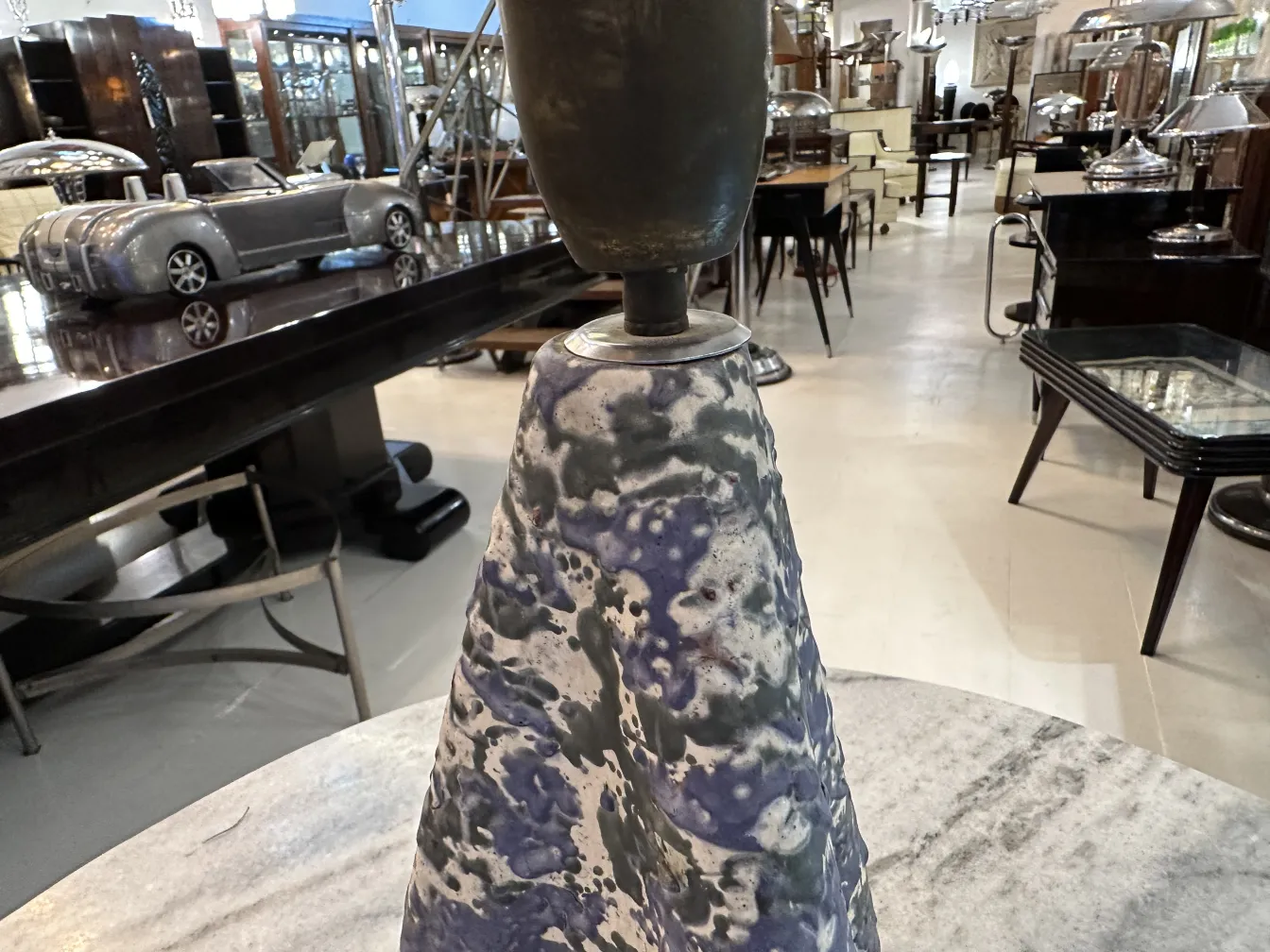 Antique table lamp with colorful base in an elegant setting.