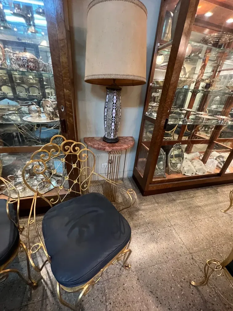 lampe de bureau ancienne avec base décorative et abat-jour beige, dans un environnement de meubles élégants