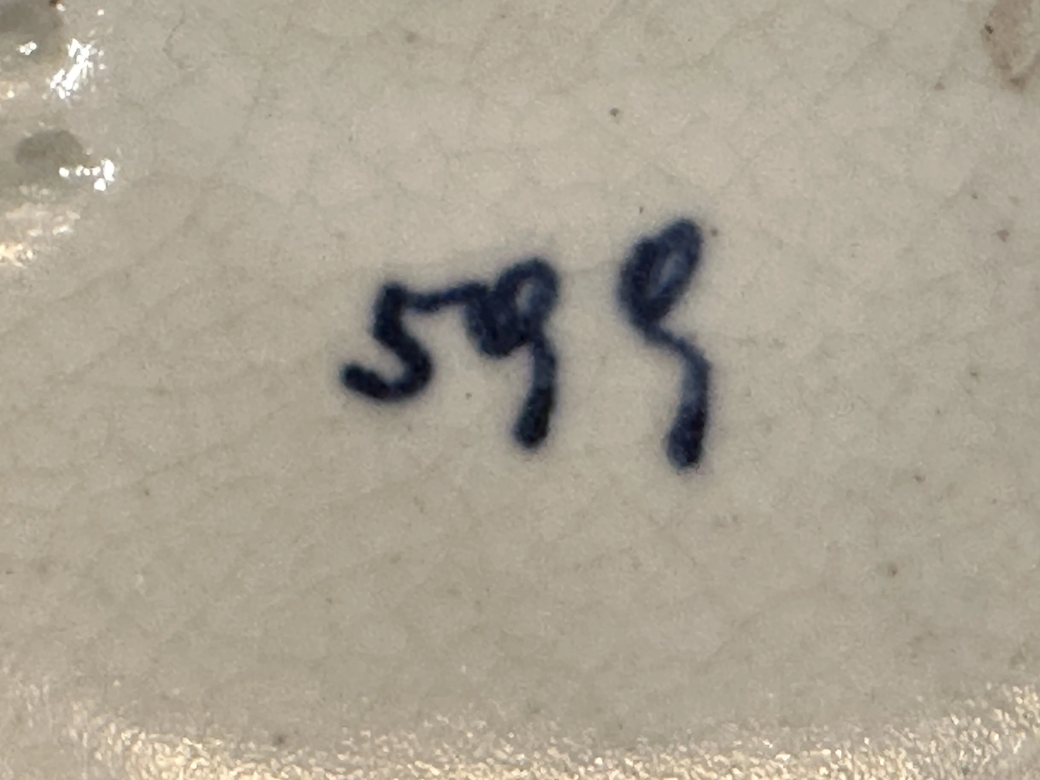 Céramique ancienne avec des détails bleus et une texture unique.