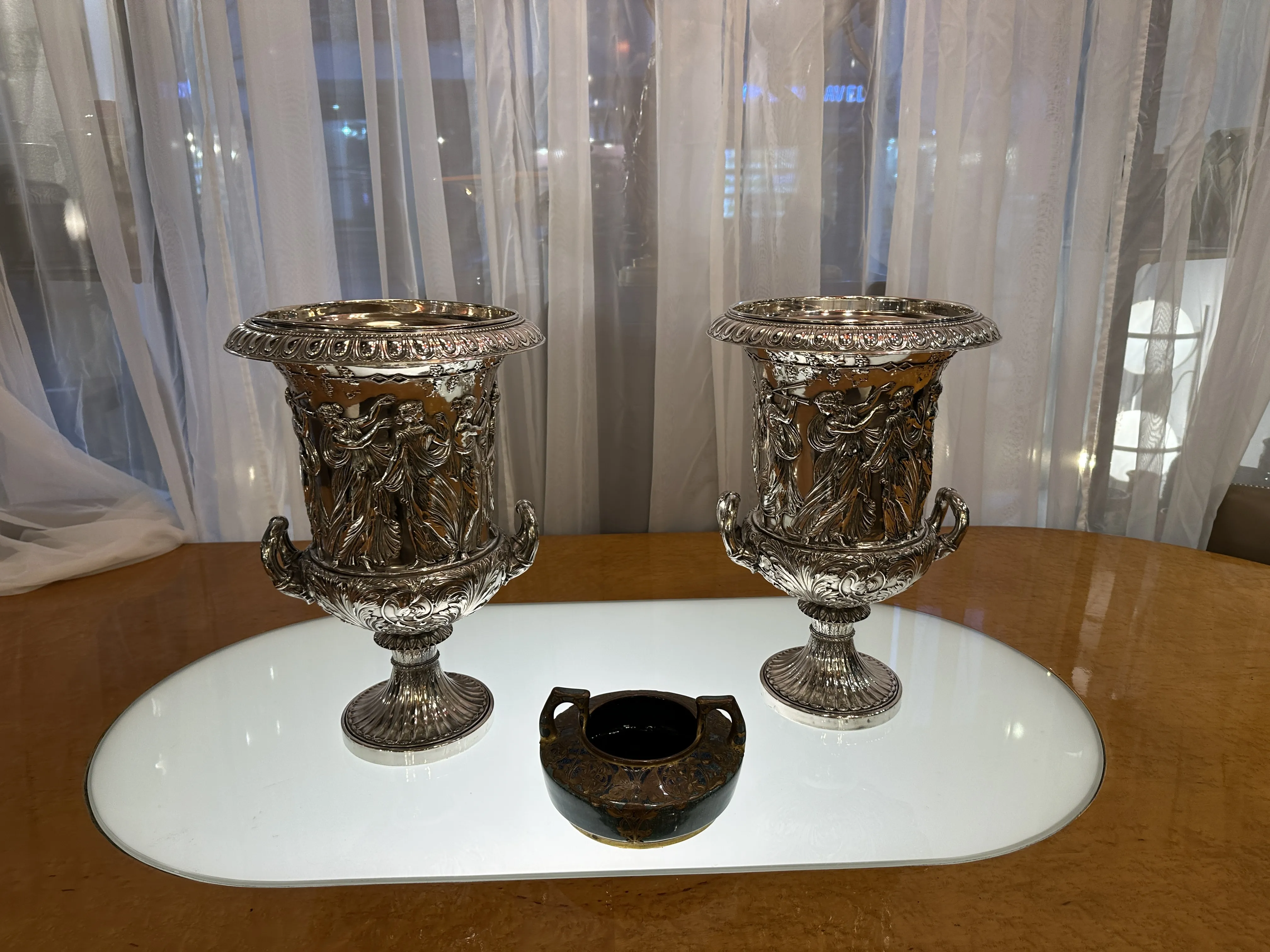 Céramique décorative ancienne avec détails en relief et ornements, exposée sur une table lisse. Deux grandes pièces et une plus petite.