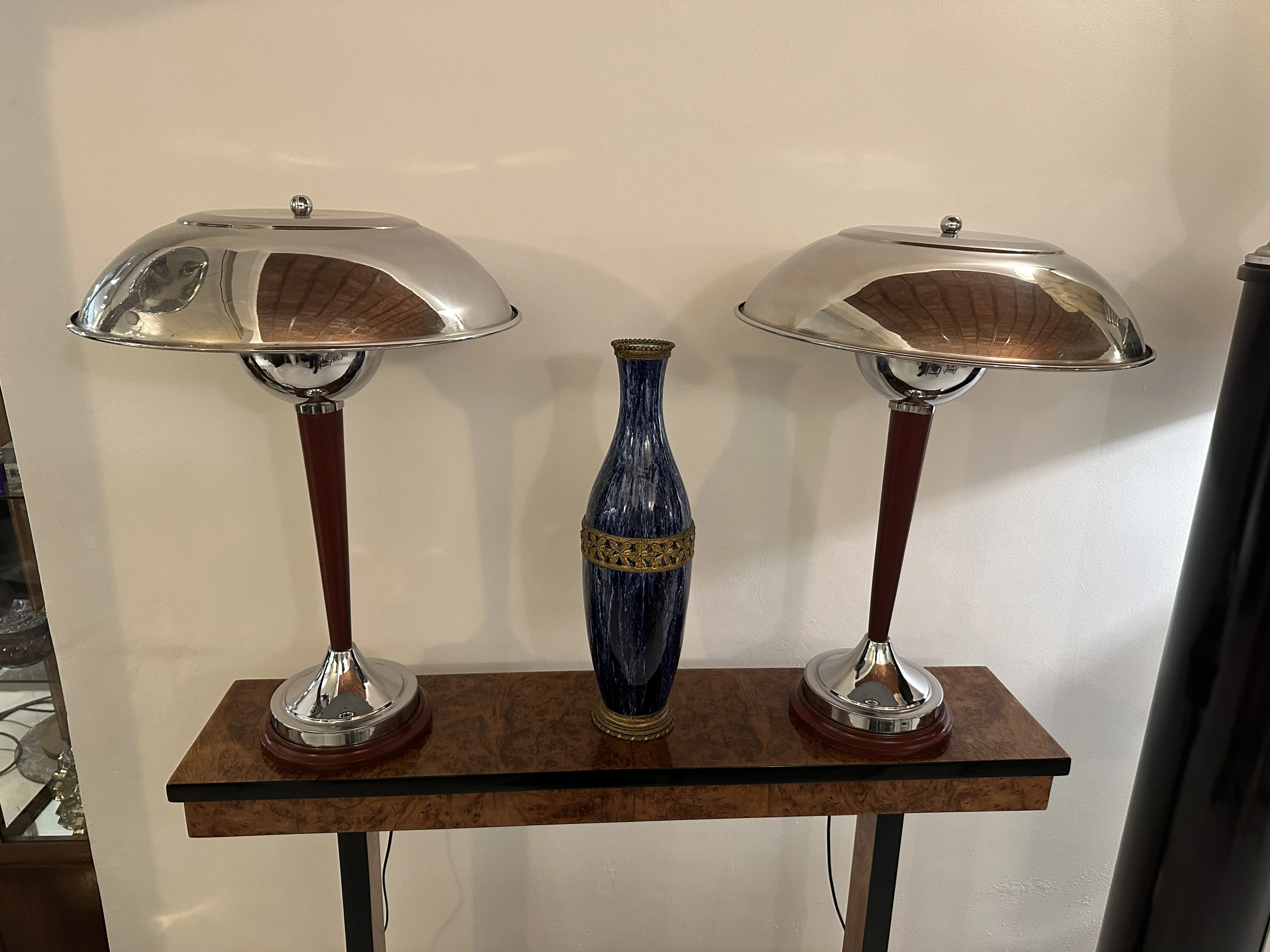 vaso de cerâmica antigo com design azul e dourado, lâmpadas modernas ao fundo