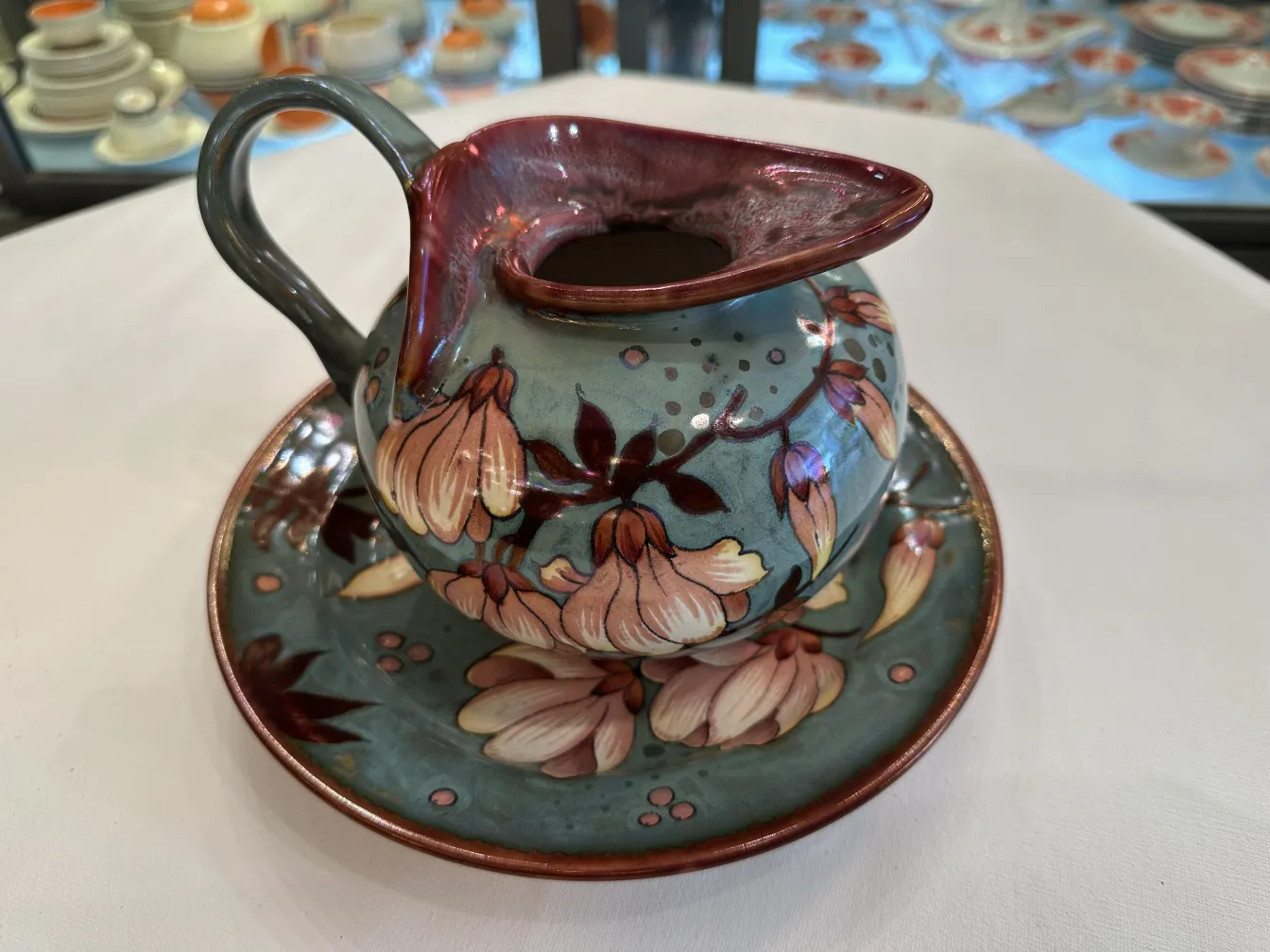 Jarro de cerâmica antiga com flores e prato decorativo