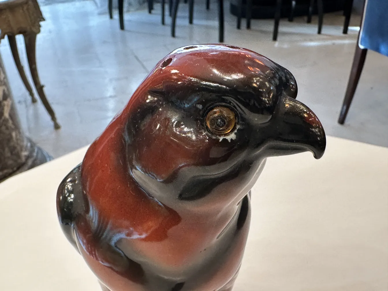 Figurilla antigua de cerámica en forma de ave, con detalles brillantes y expresivos.