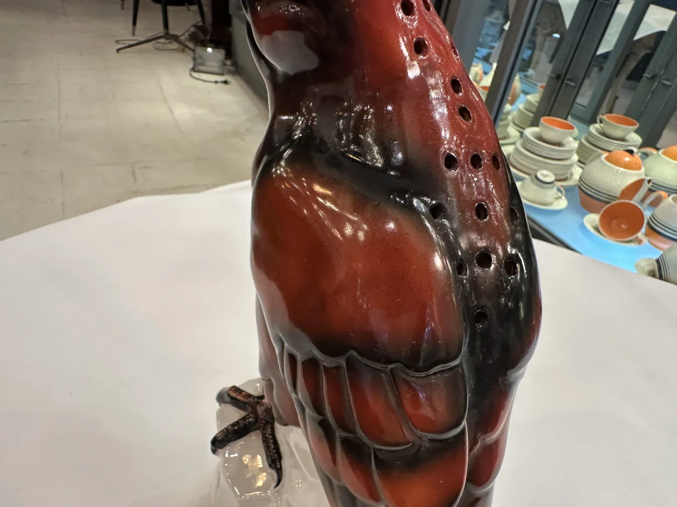 Figurilla antigua de cerámica en forma de ave, con detalles brillantes y expresivos.