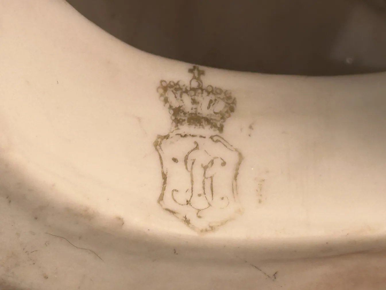 Cerâmica antiga com detalhes de emblemas reais.