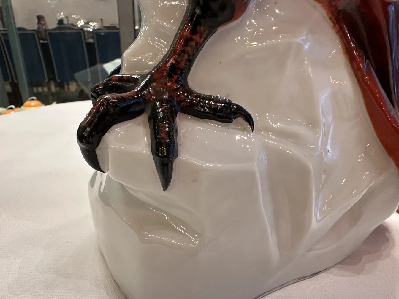 Figurilla antigua de cerámica en forma de ave, con detalles brillantes y expresivos.