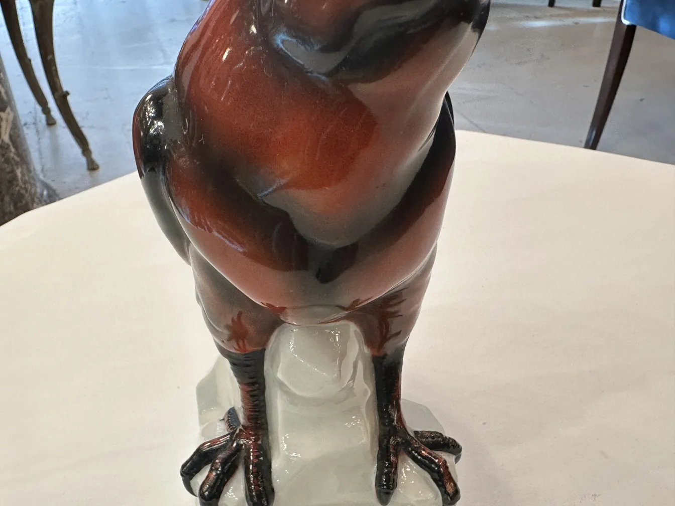 Antica figurina in ceramica a forma di uccello, con dettagli lucidi ed espressivi.