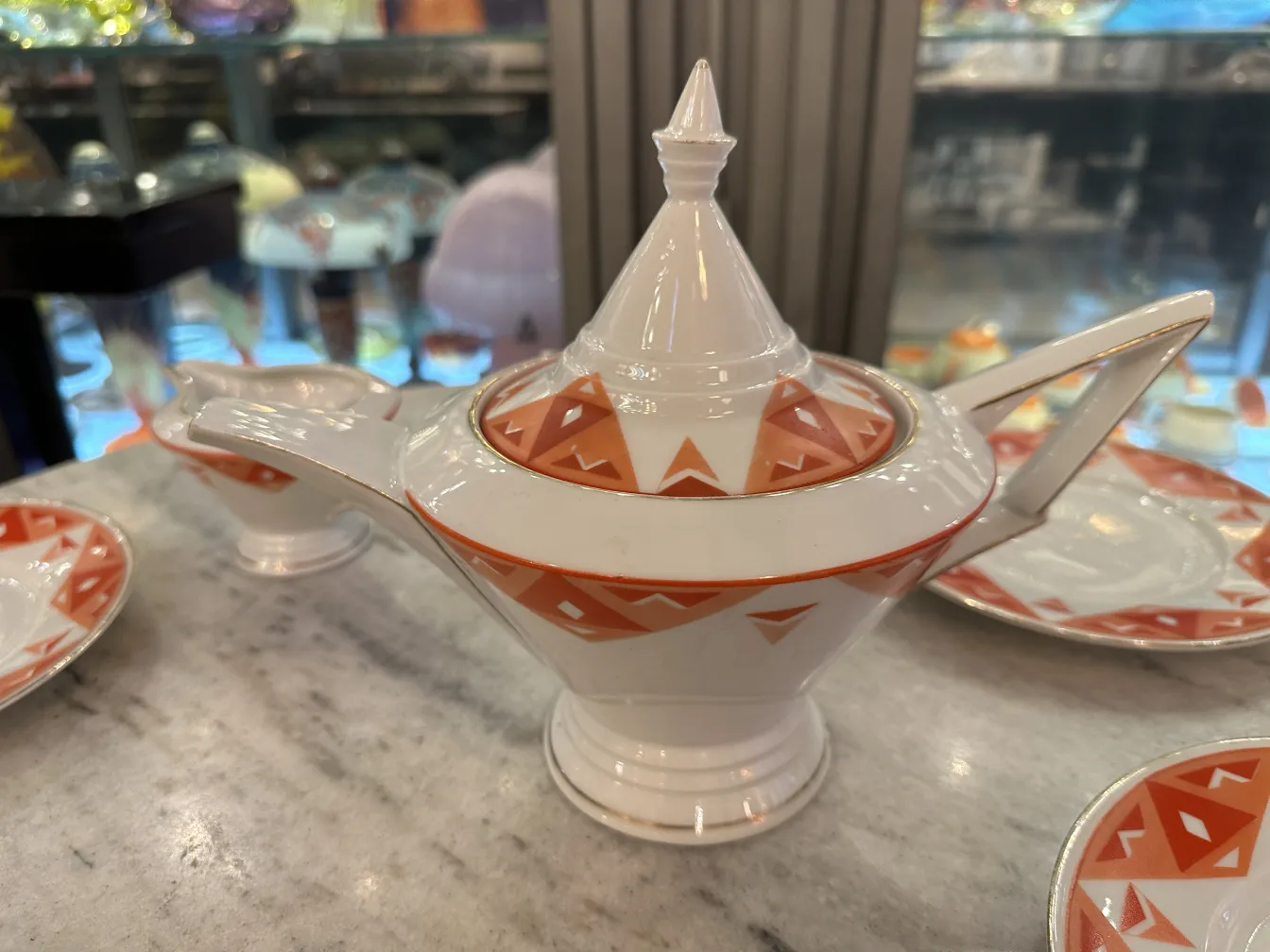 Service à thé ancien Volkstedt avec motifs colorés sur la table.