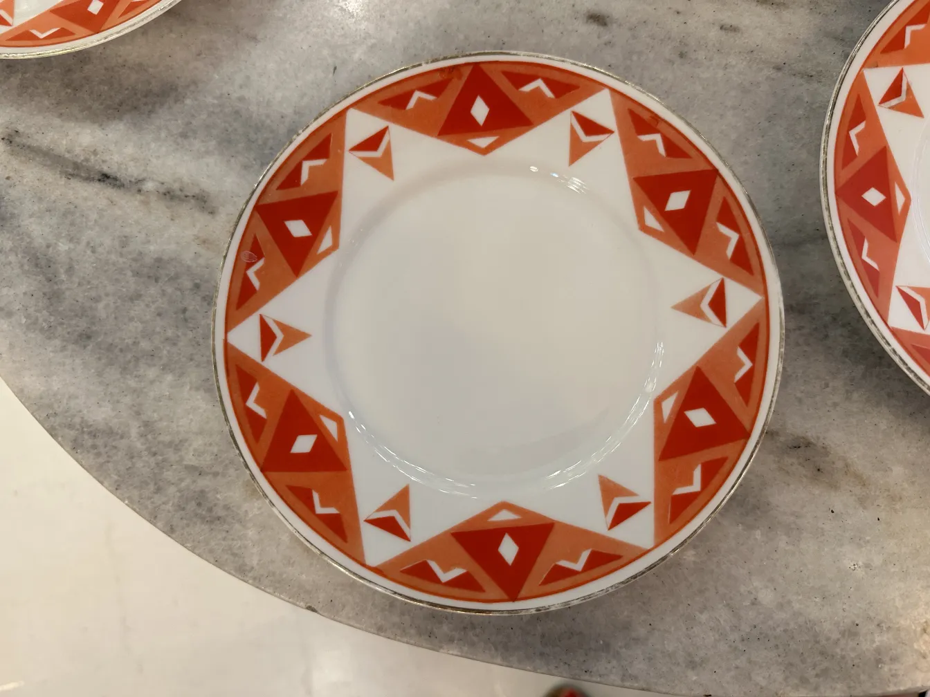 Service à thé ancien Volkstedt avec motifs colorés sur la table.