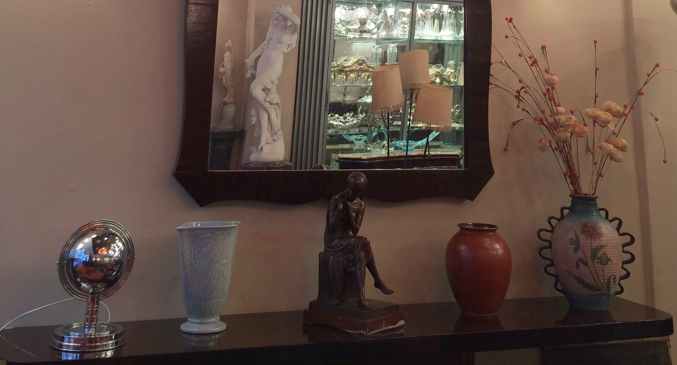 Antigüedades decorativas de cerámica en una mesa con varios elementos.