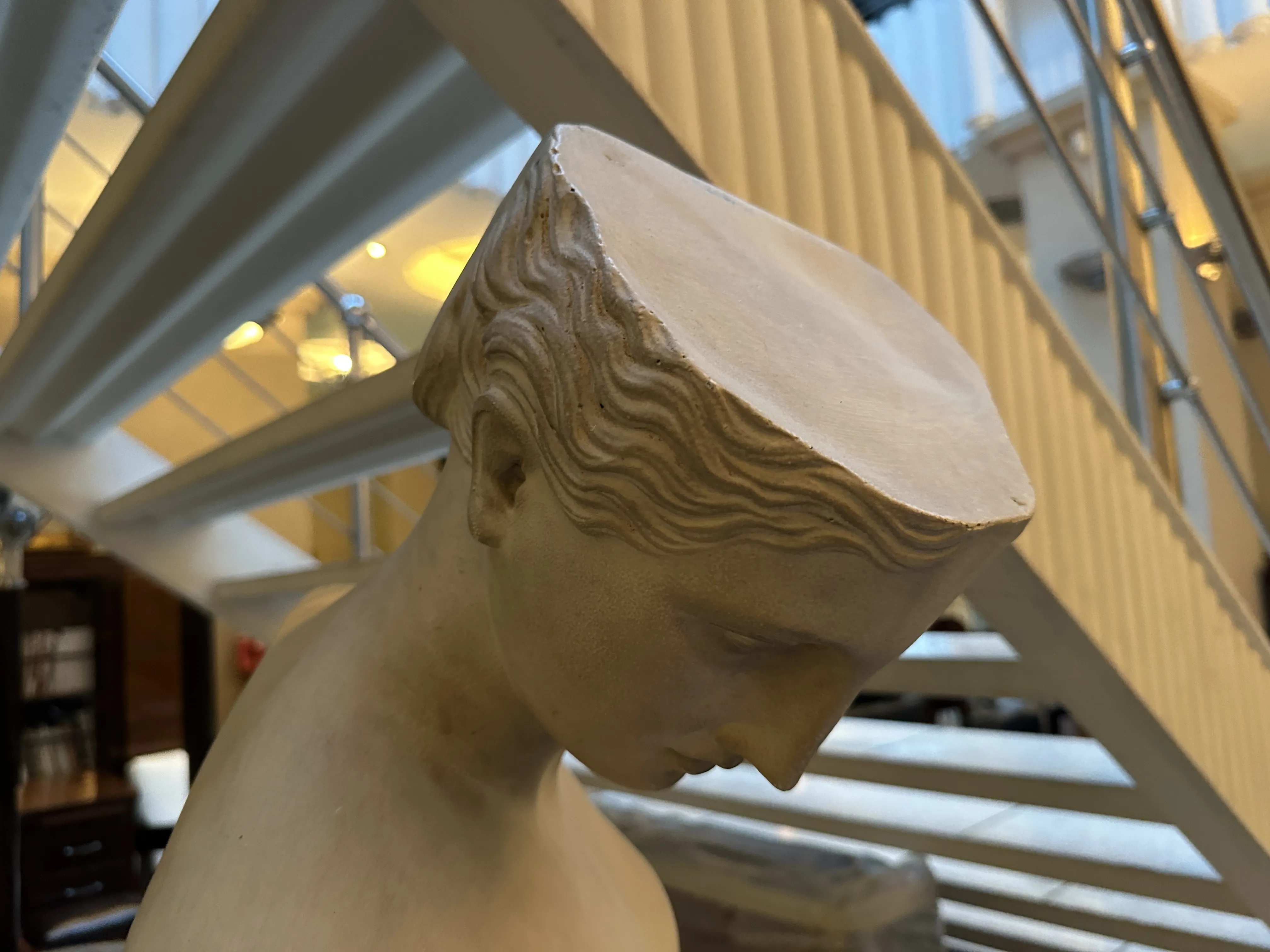 scultura antica con caratteristiche facciali, sfondo di scale