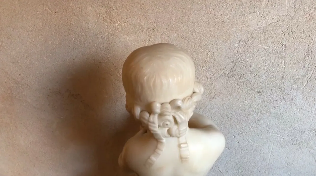 scultura antica di un bambino che tiene un uccello
