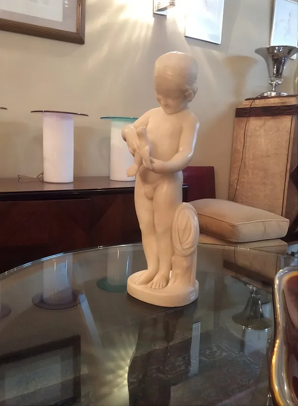 antique sculpture of a child holding a bird