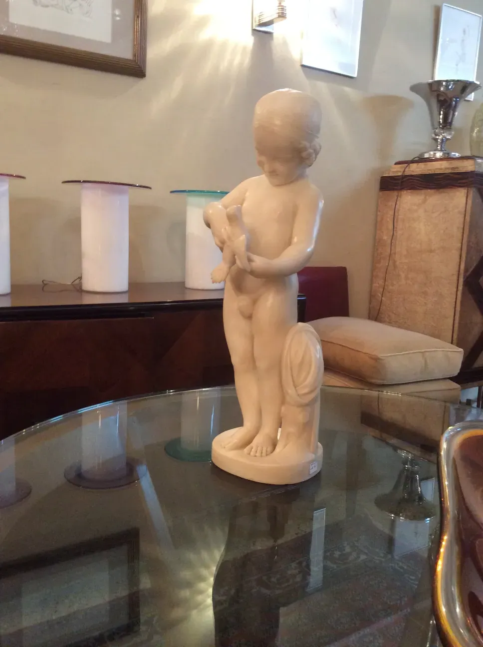 escultura antigua de un niño sosteniendo un pájaro