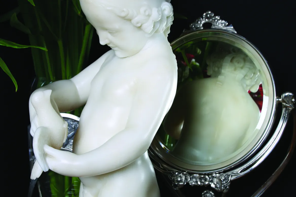 antique sculpture of a child holding a bird