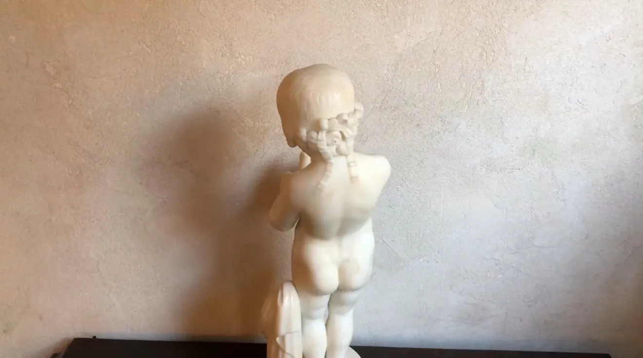 escultura antigua de un niño sosteniendo un pájaro