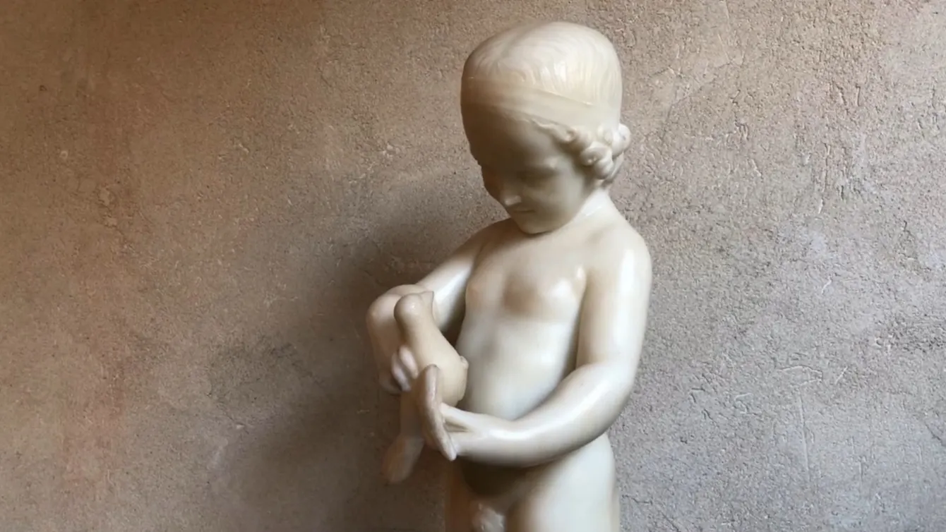 escultura antiga de uma criança segurando um pássaro