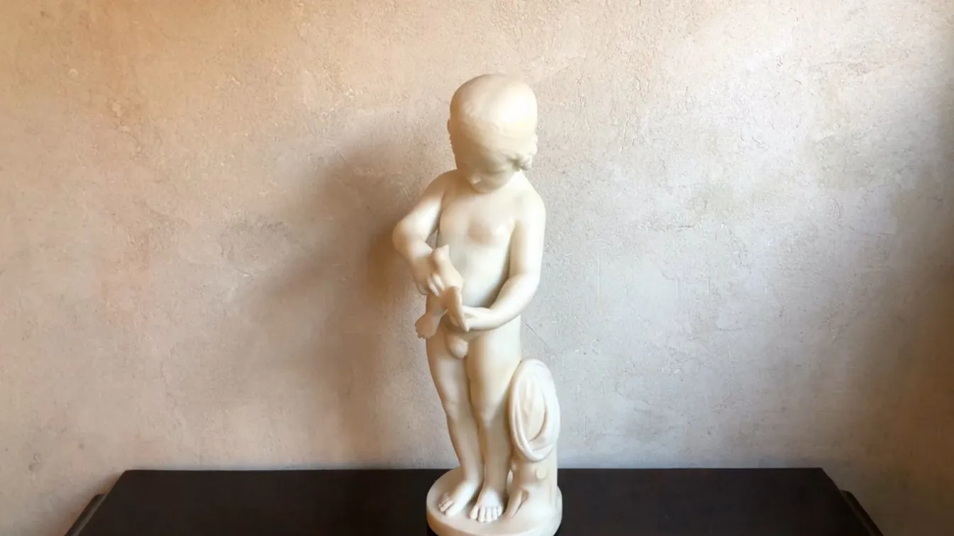 escultura antiga de uma criança segurando um pássaro