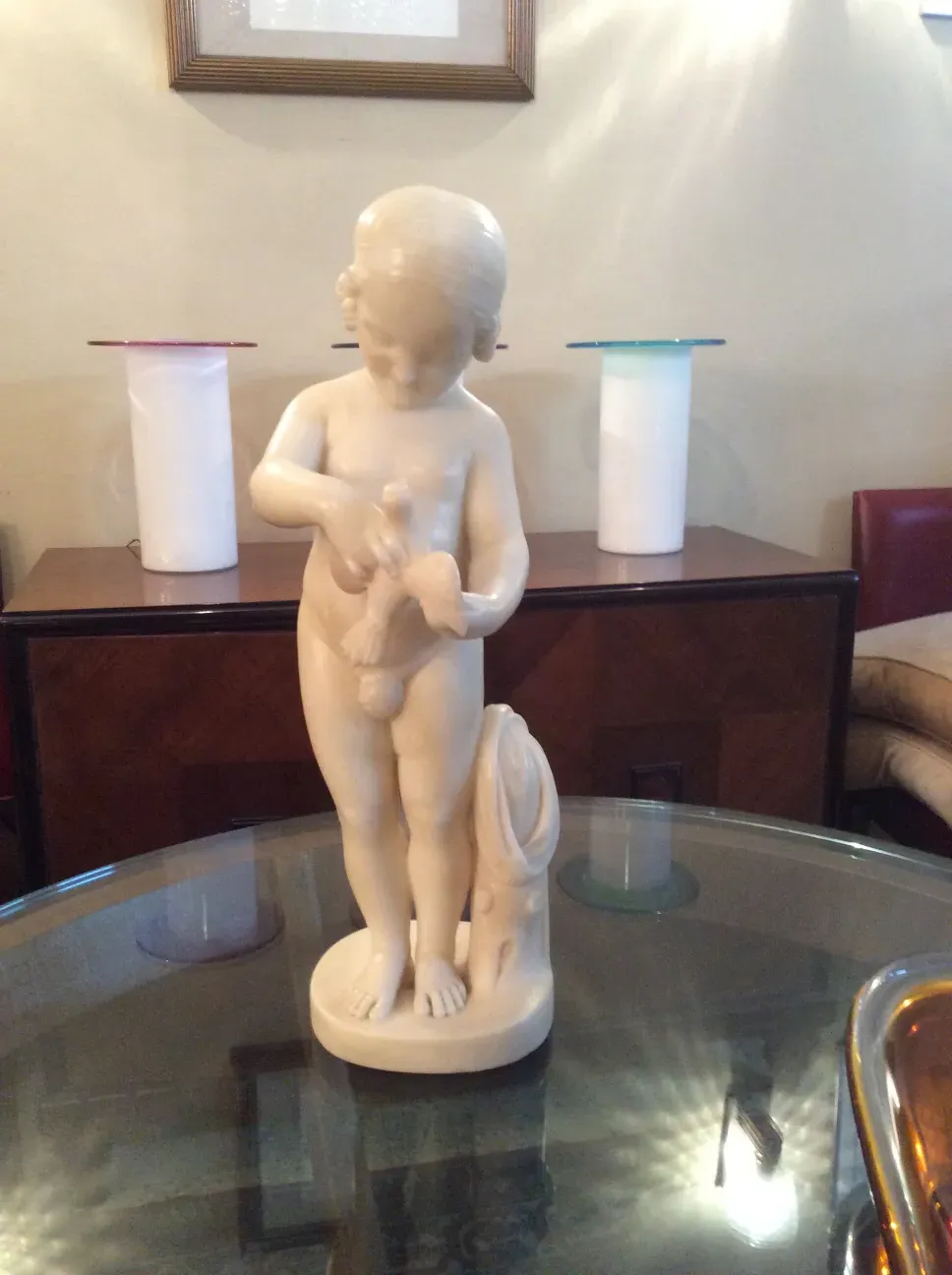 antique sculpture of a child holding a bird