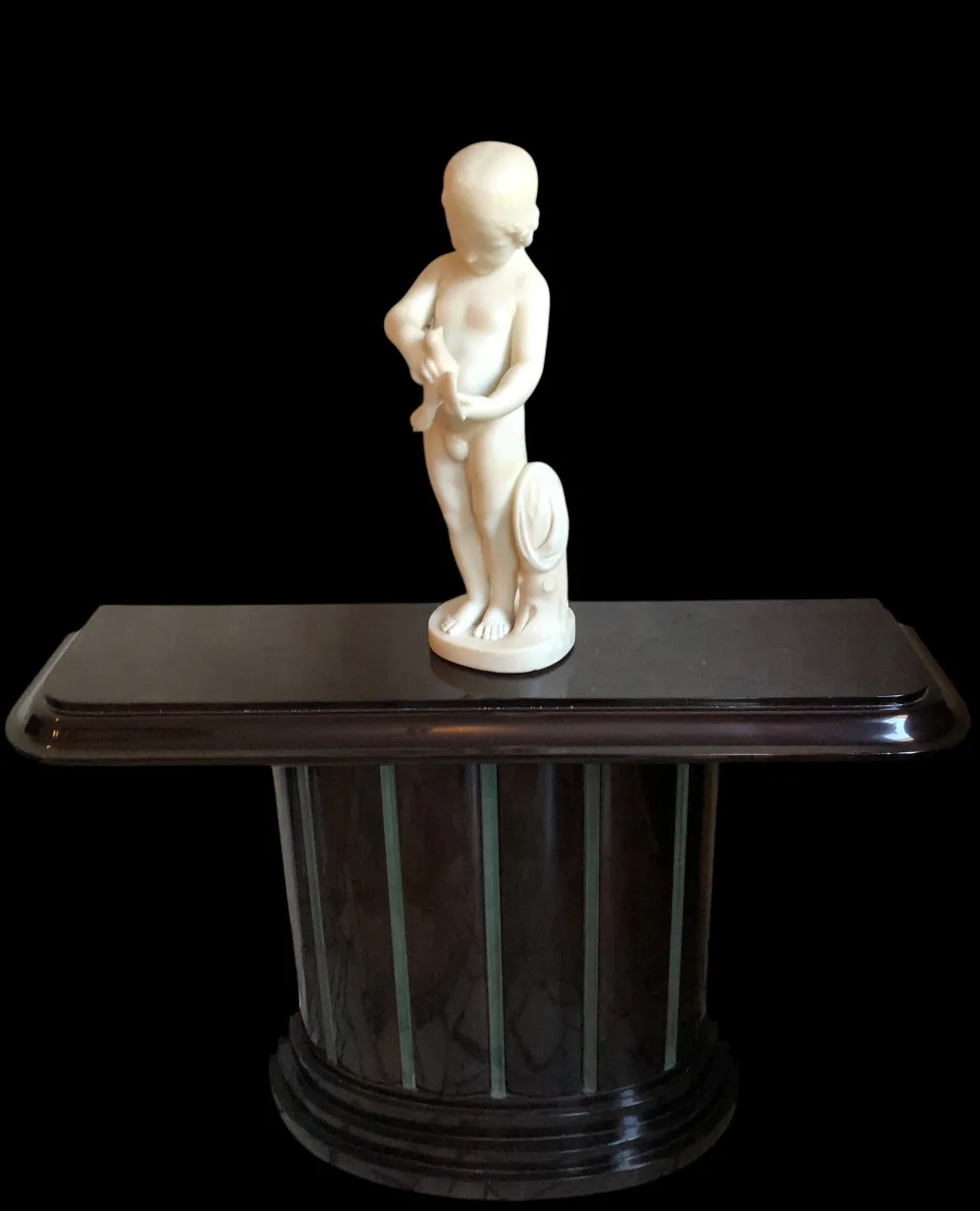 antique sculpture of a child holding a bird