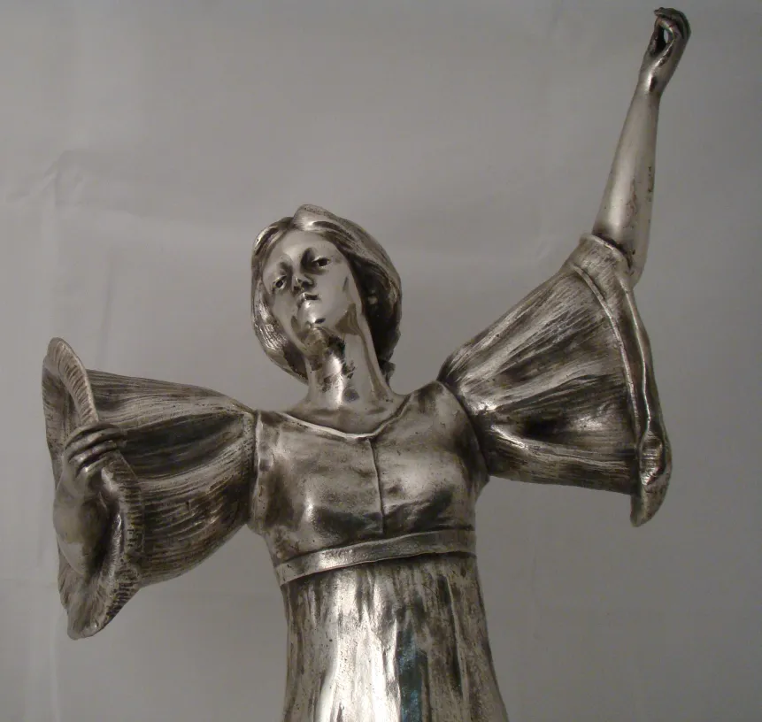 scultura antica di figura femminile con braccia alzate