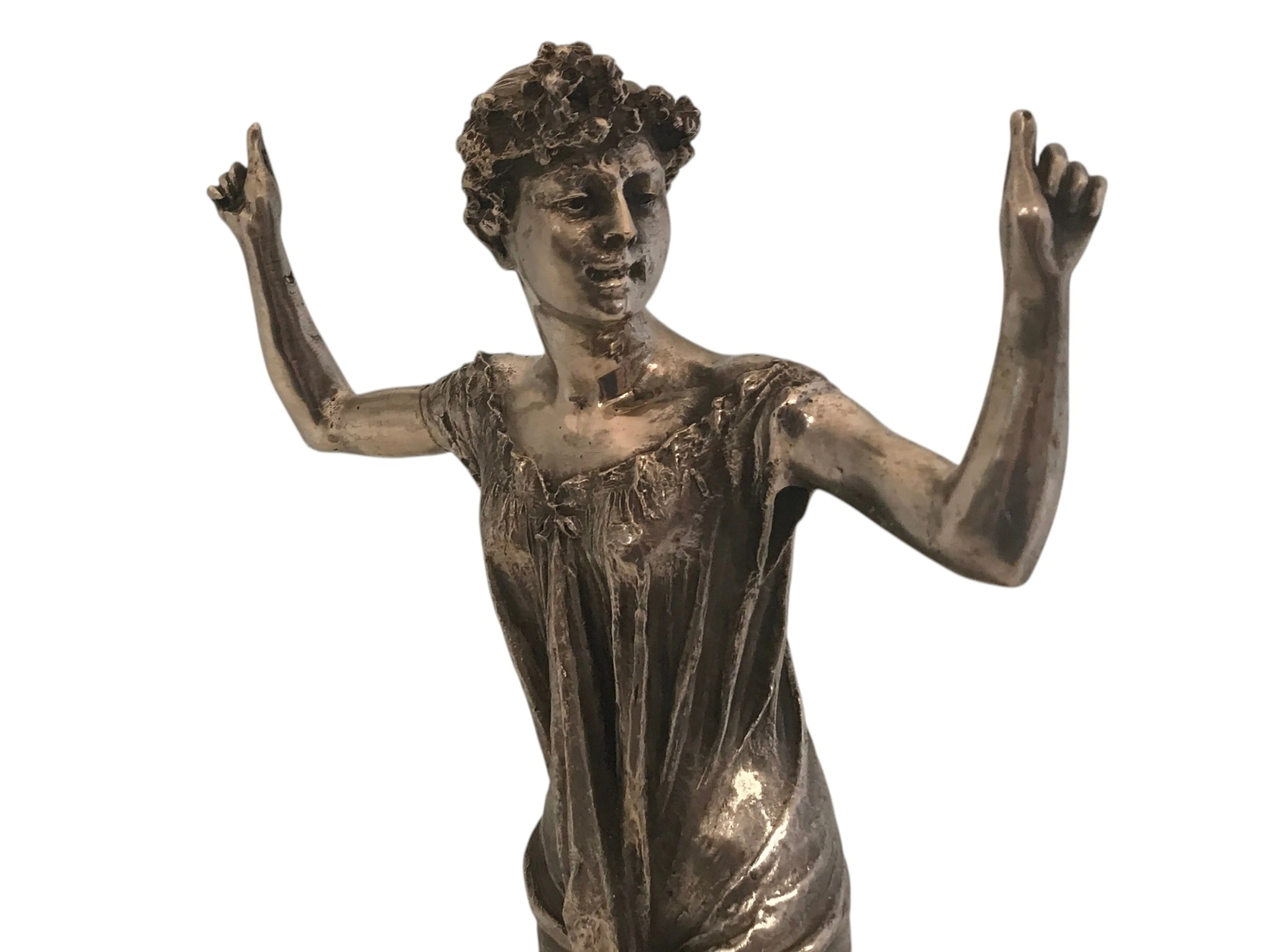 escultura antigua de una figura femenina con brazos levantados