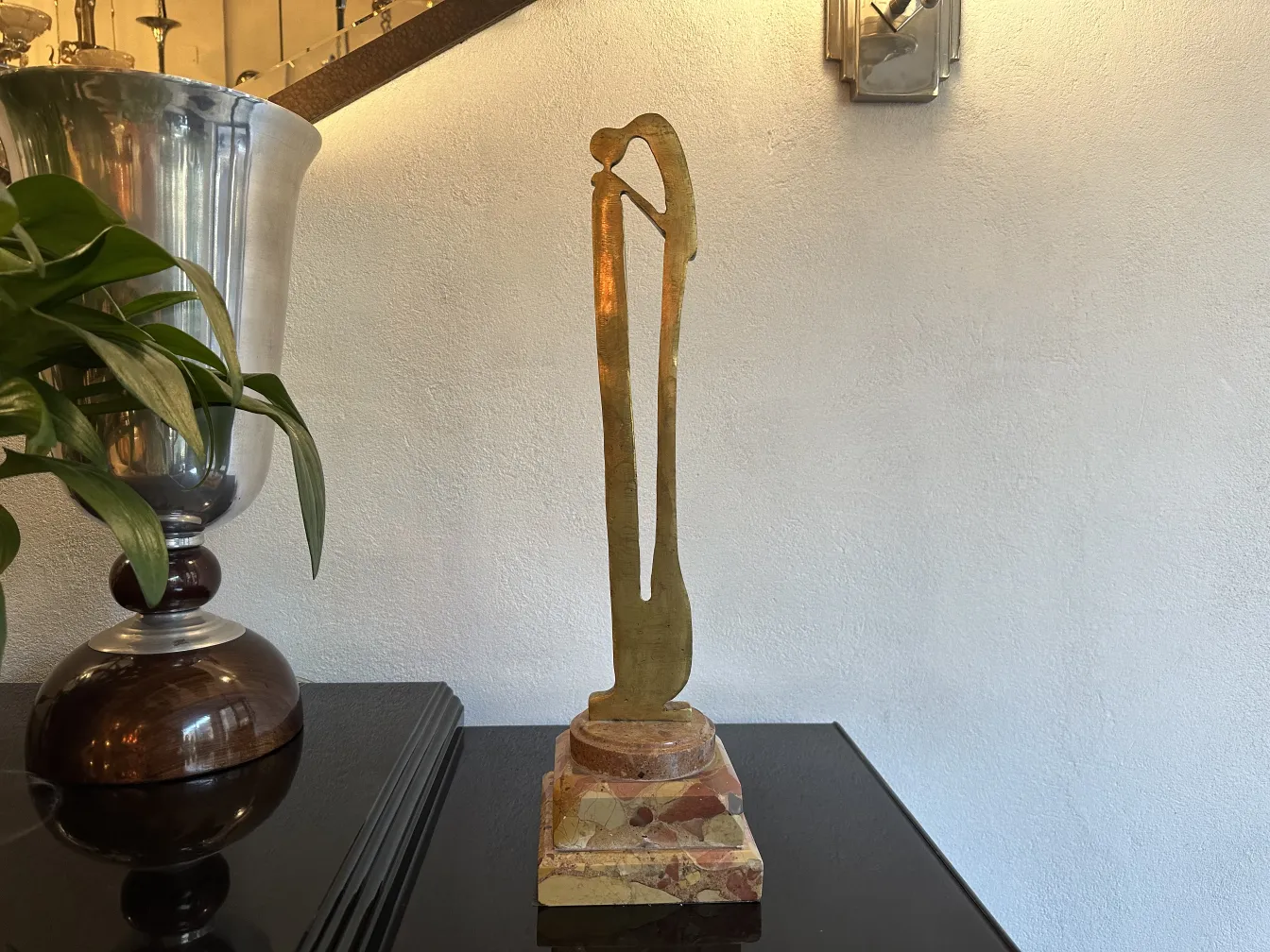 Escultura antigua con forma estilizada y base decorativa.
