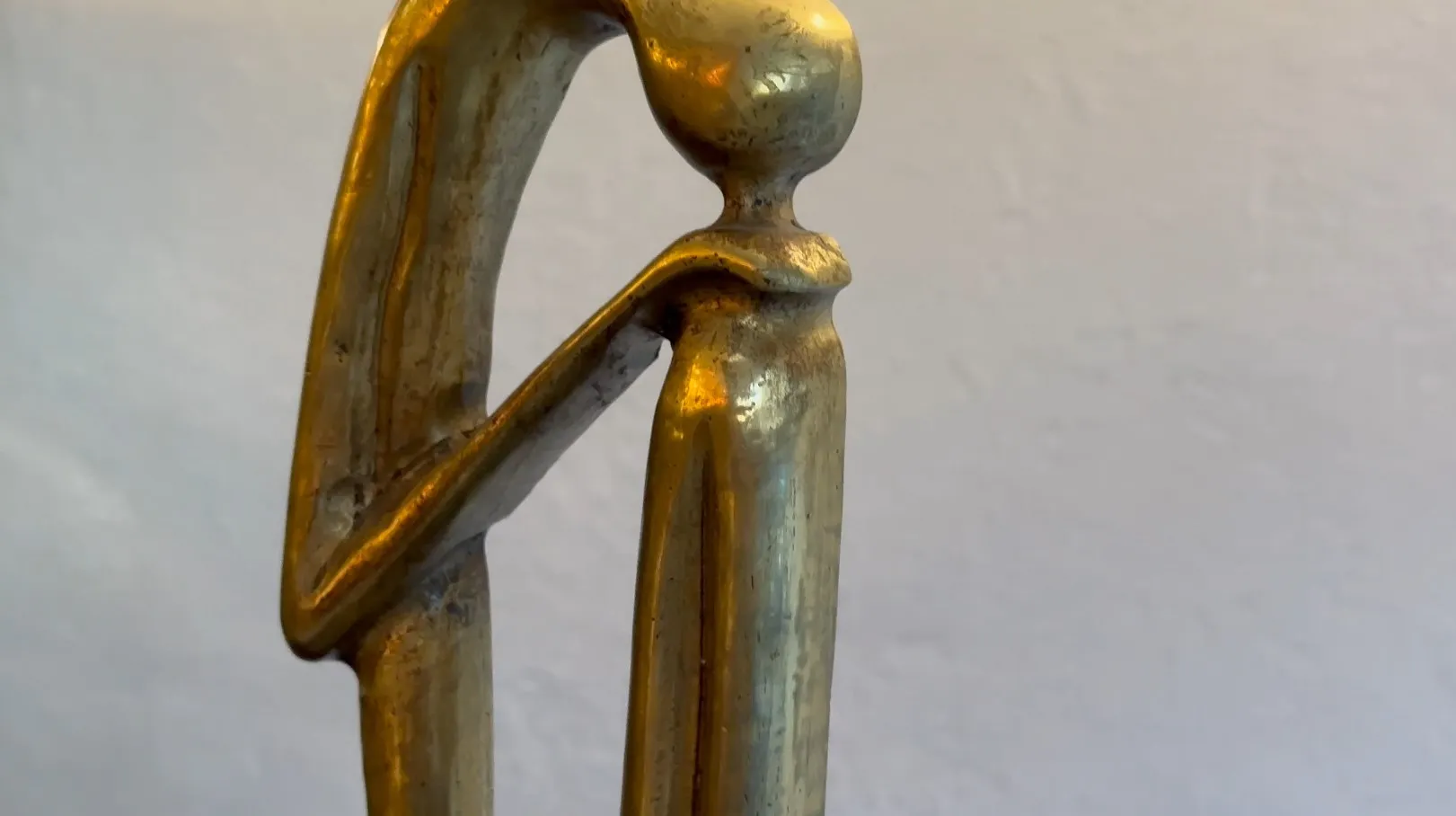 Escultura antiga com forma elegante e base decorativa.