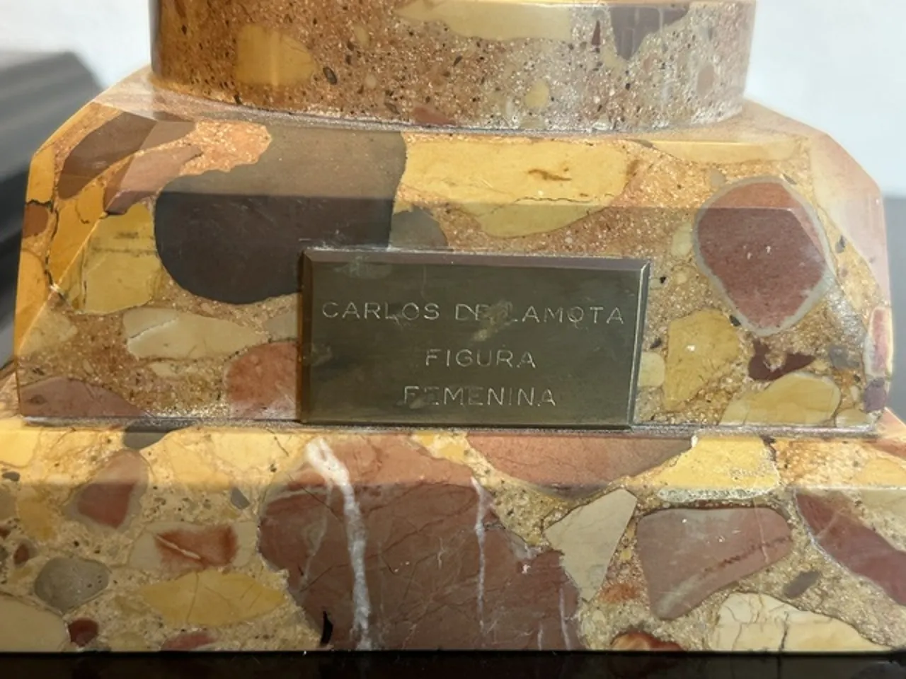 Scultura antica con forma elegante e base decorativa.