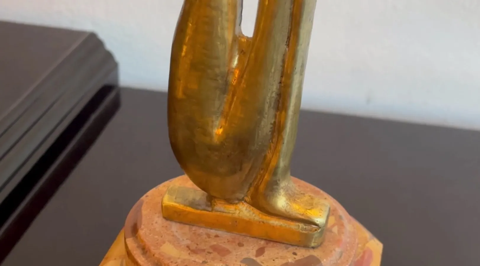 Scultura antica con forma elegante e base decorativa.