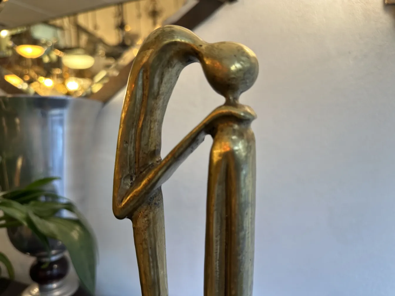 Escultura antiga com forma elegante e base decorativa.