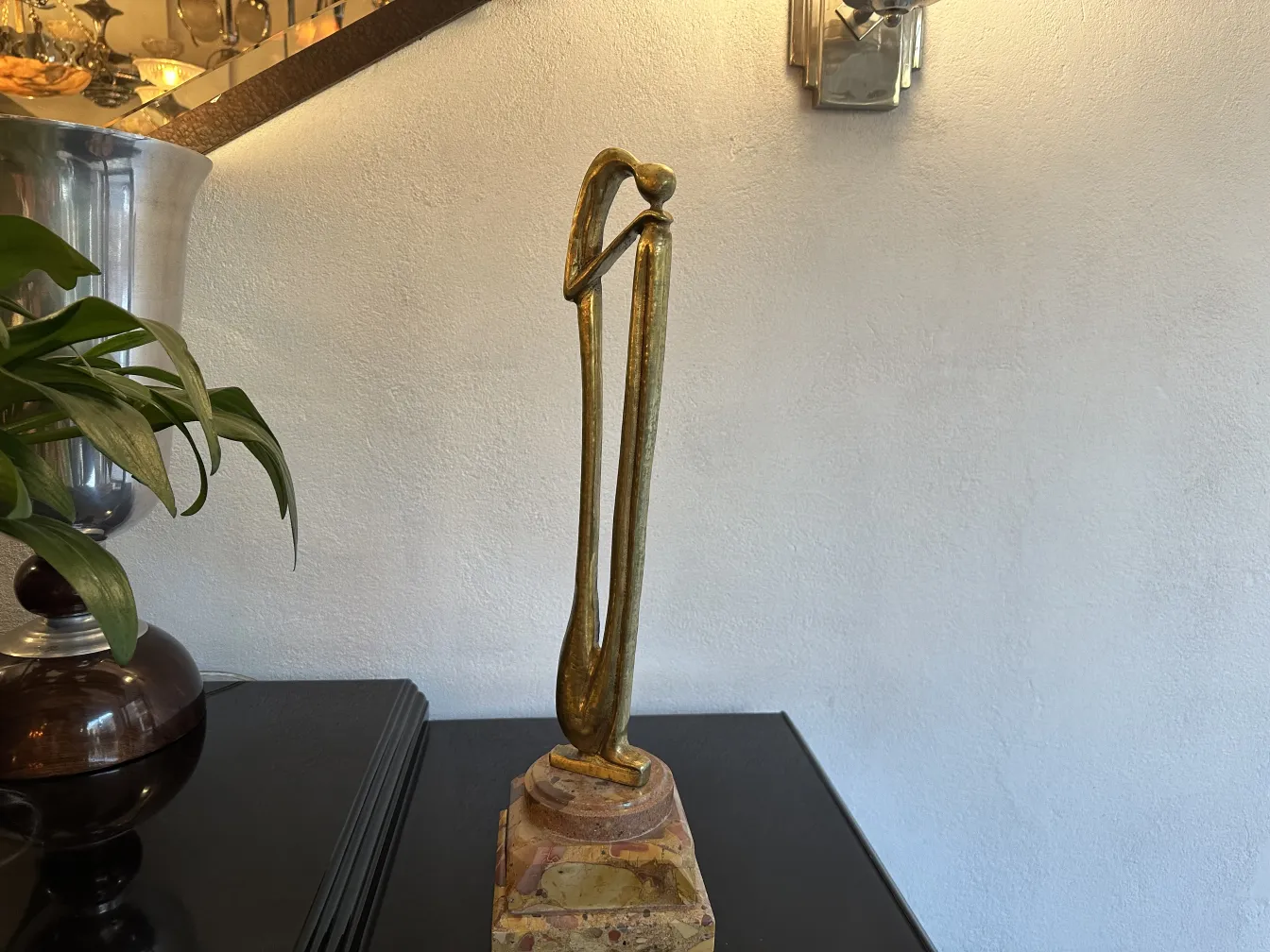 Escultura antiga com forma elegante e base decorativa.