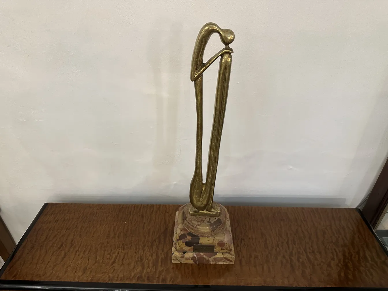 Escultura antiga com forma elegante e base decorativa.
