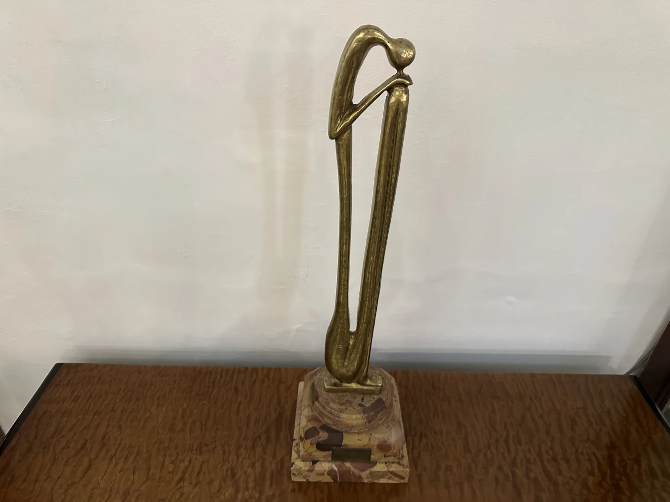 Scultura antica con forma elegante e base decorativa.