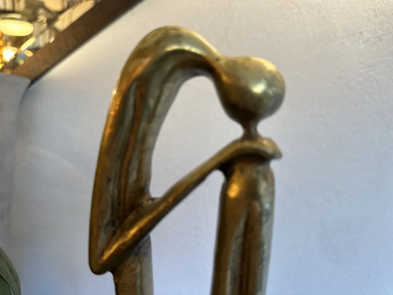 Escultura antiga com forma elegante e base decorativa.