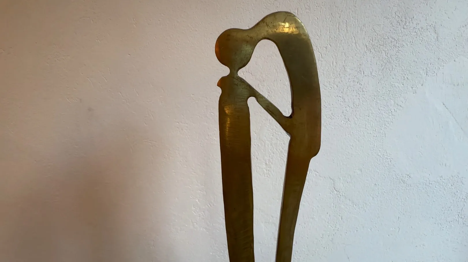 Escultura antiga com forma elegante e base decorativa.