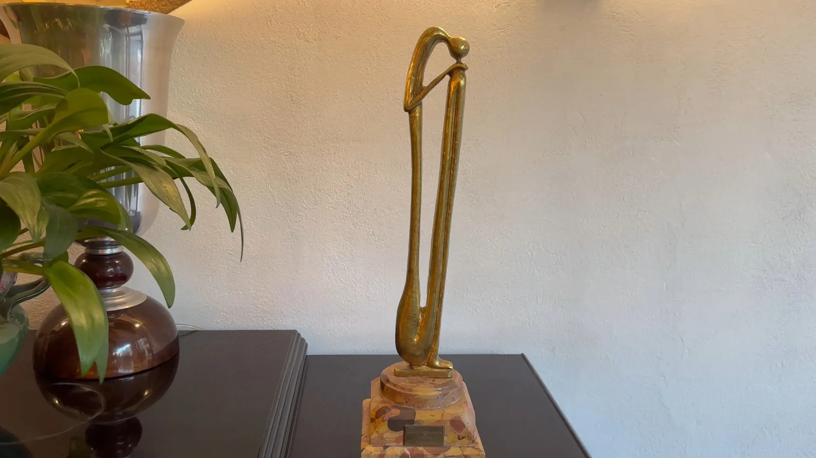 Escultura antiga com forma elegante e base decorativa.