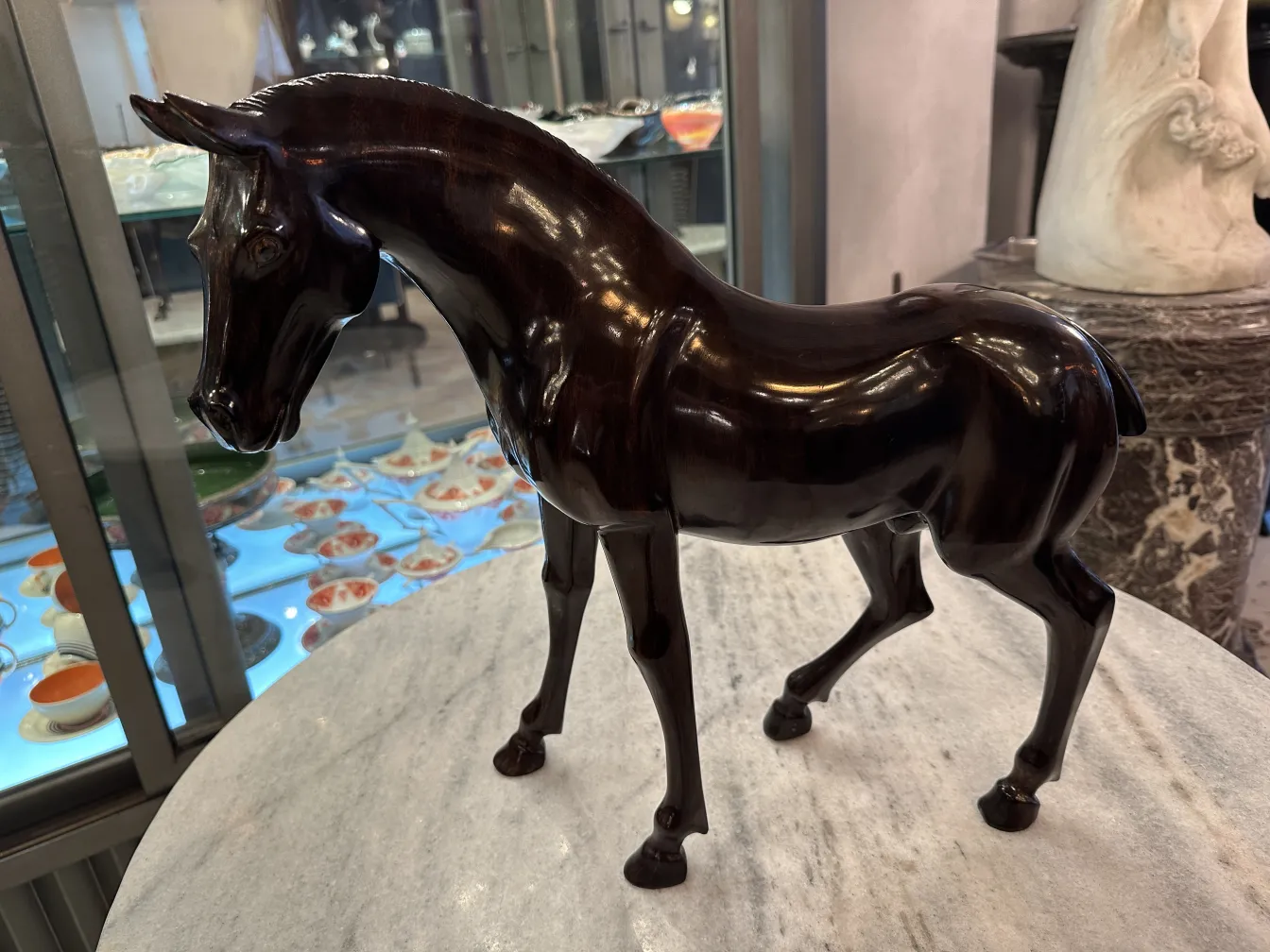 Escultura antigua de un caballo con acabado brillante.