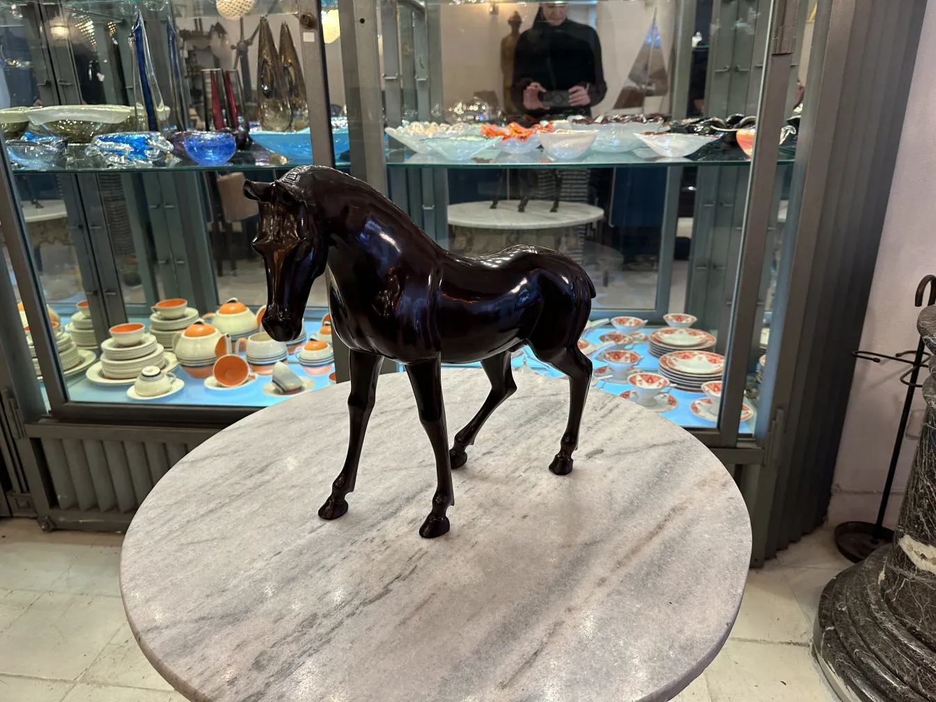 Sculpture ancienne d'un cheval avec une finition brillante.