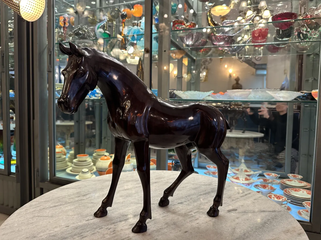 Antique sculpture of a horse with a shiny finish.
